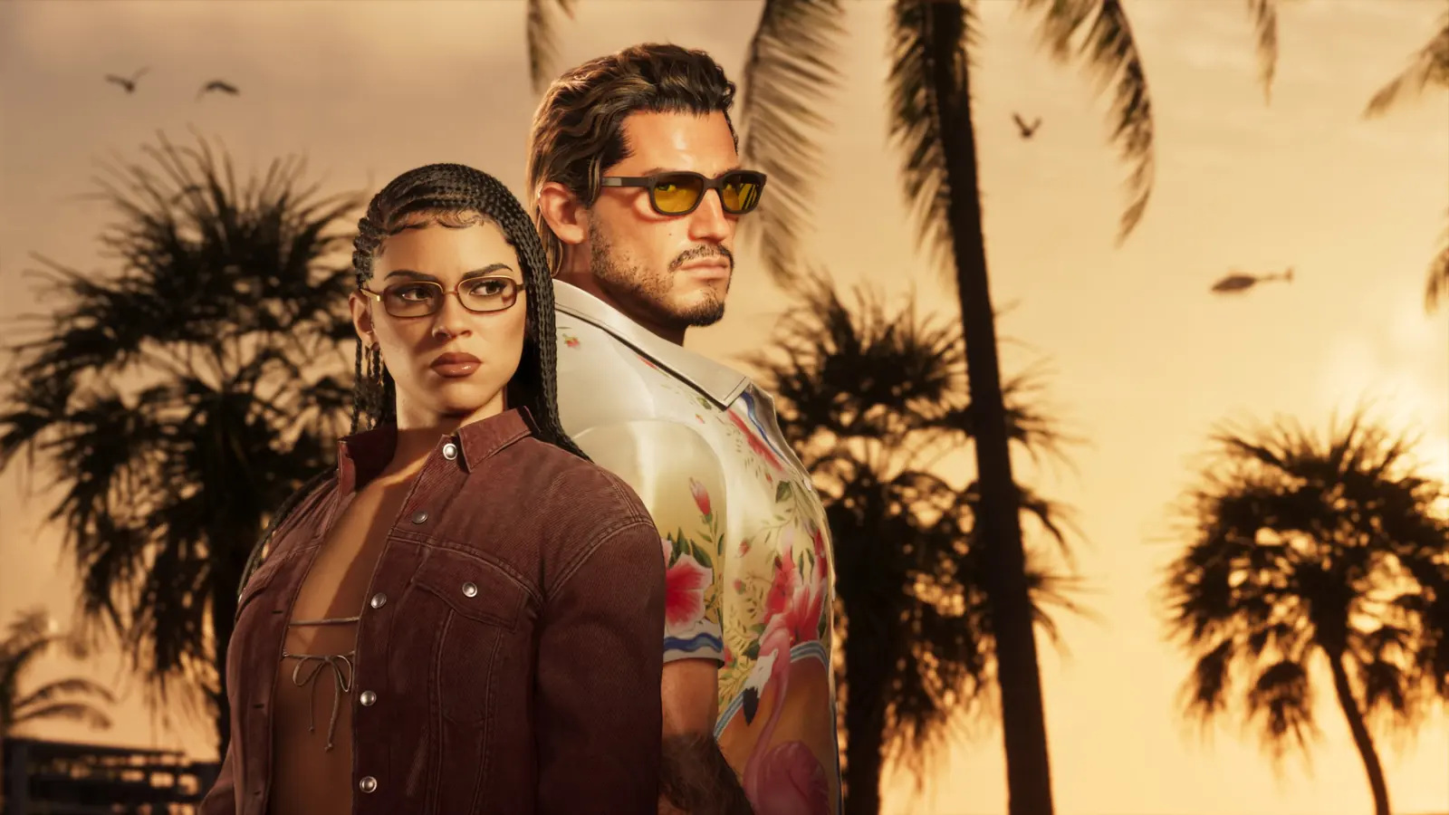 Jason and Lucia stand back to back against palm trees at sunset