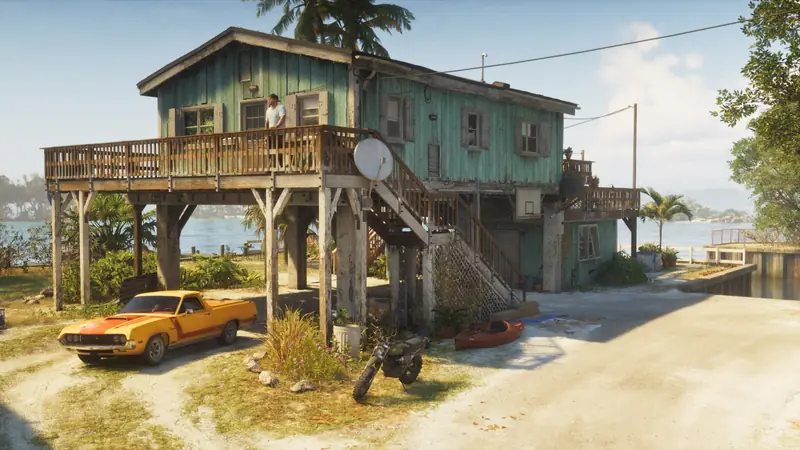 A stilt house on the water with a yellow pickup parked out front